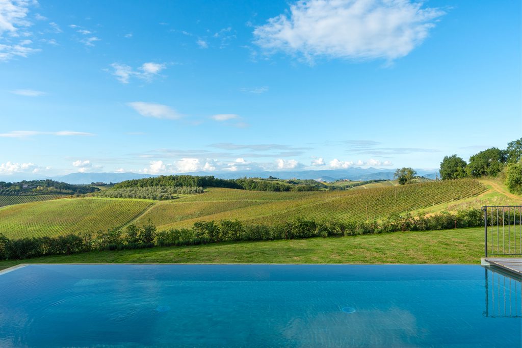 Piscina a sfioro di Podere San Martino, con il bordo dell'acqua allineato alle vigne e alle colline di Cerreto Guidi.