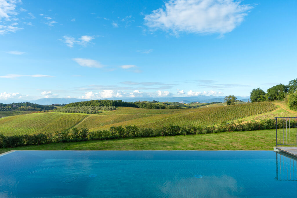 Piscina a sfioro di Podere San Martino, con il bordo dell'acqua allineato alle vigne e alle colline di Cerreto Guidi.