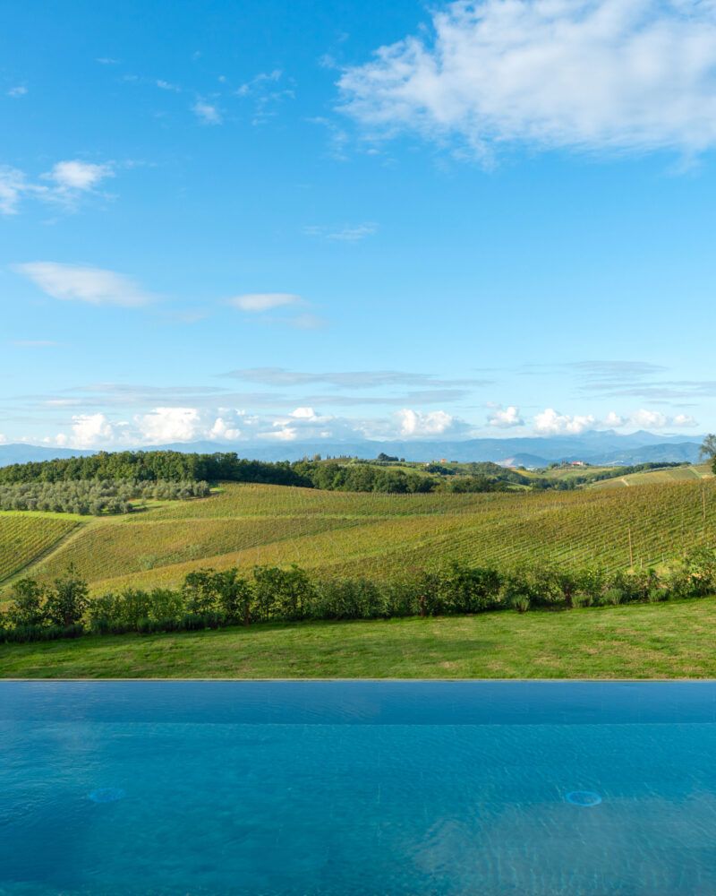 Piscina a sfioro di Podere San Martino, con il bordo dell'acqua allineato alle vigne e alle colline di Cerreto Guidi.